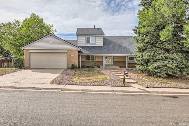 traditional home with concrete driveway, brick siding, roof with shingles, and an attached garage