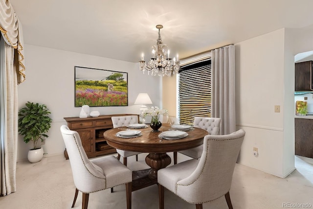 dining space with finished concrete floors and a notable chandelier