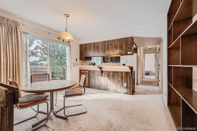 dining space featuring light carpet