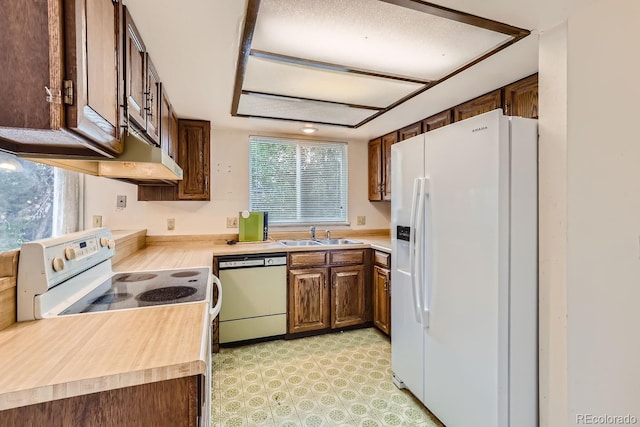 kitchen with white appliances, light countertops, a sink, and light floors