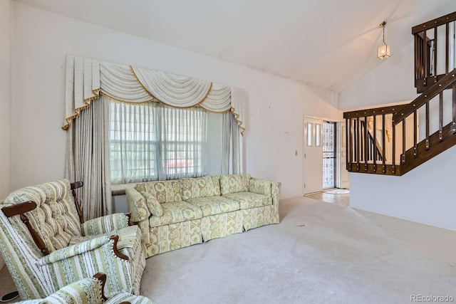 carpeted living area with stairway and vaulted ceiling