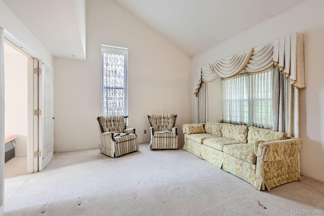 sitting room with high vaulted ceiling and carpet