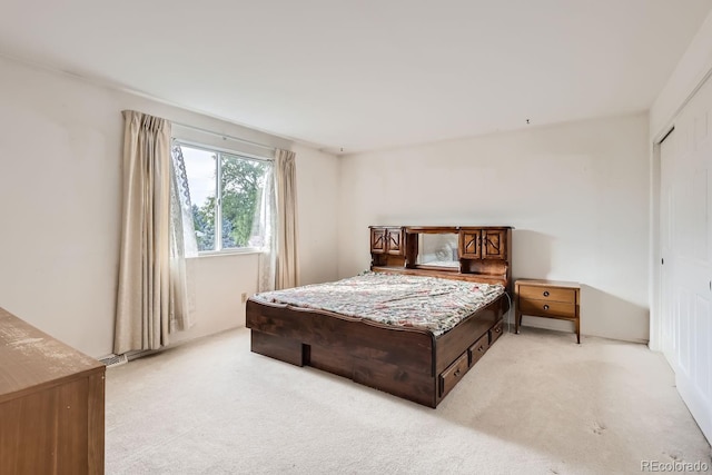 bedroom with a closet and light colored carpet