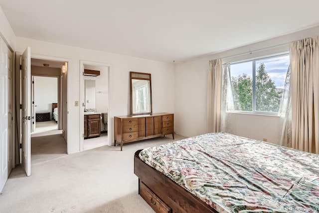 bedroom with light colored carpet and connected bathroom