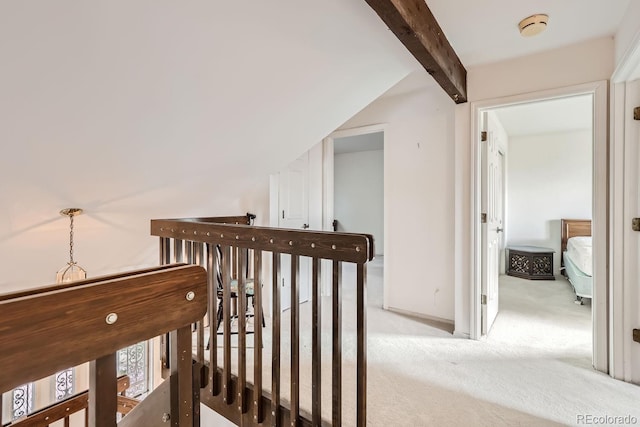 hall featuring light colored carpet, lofted ceiling with beams, and an upstairs landing