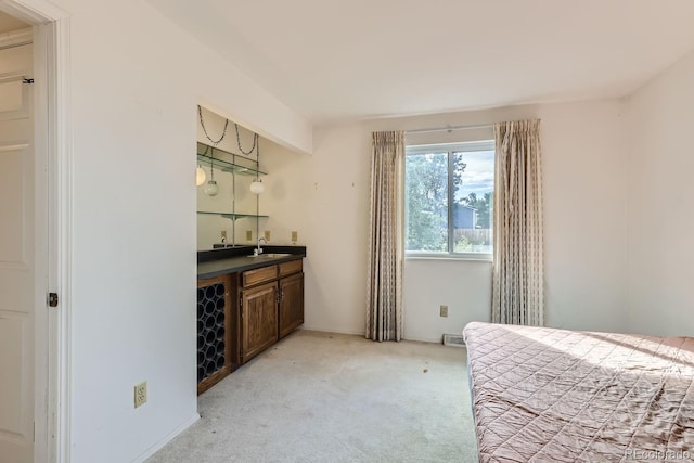 bedroom with light carpet, a sink, visible vents, and wet bar