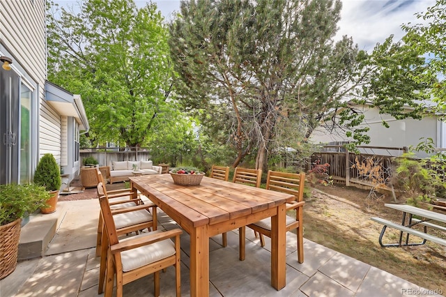 view of patio / terrace featuring fence, outdoor dining area, and an outdoor living space