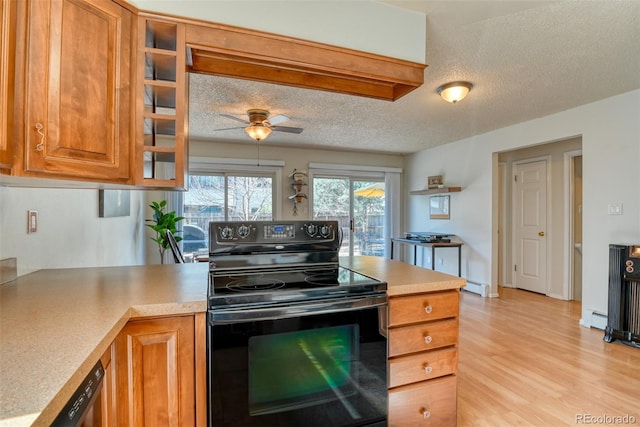 6486 Hawkeye Cir, Colorado Springs, CO 80919 - kitchen with light wood finished floors, light countertops, electric range, and brown cabinetry