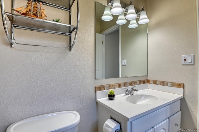 6486 Hawkeye Cir, Colorado Springs, CO 80919 - half bath with toilet, vanity, a textured wall, and a chandelier