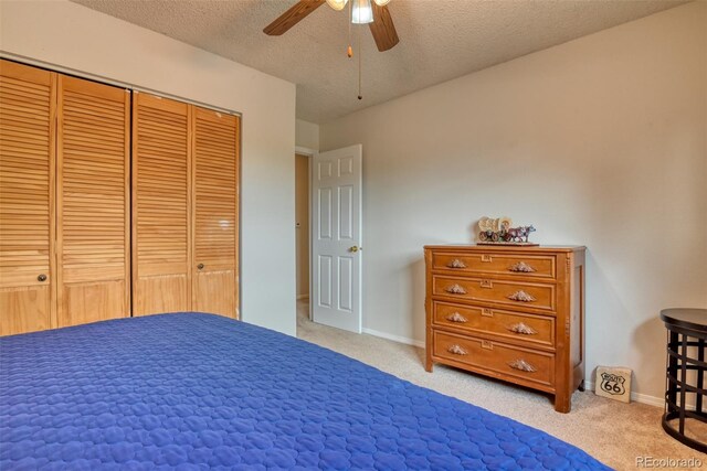 6486 Hawkeye Cir, Colorado Springs, CO 80919 - unfurnished bedroom featuring a closet, a textured ceiling, baseboards, ceiling fan, and light carpet