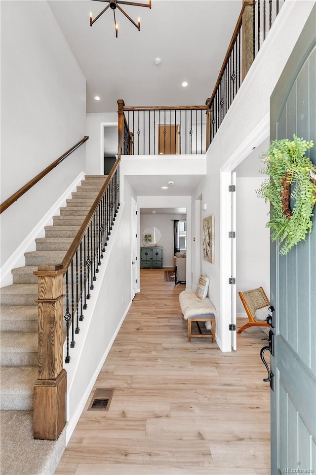 821 Boulder Peak Ave, Erie, CO 80516 - entrance foyer with stairway, a chandelier, light wood-style flooring, recessed lighting, and a towering ceiling