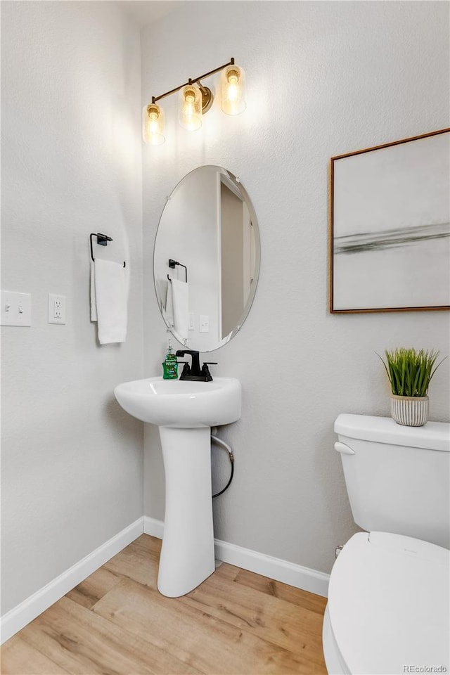 821 Boulder Peak Ave, Erie, CO 80516 - bathroom featuring wood finished floors, toilet, baseboards, and a sink