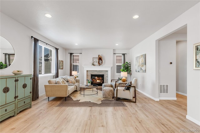 821 Boulder Peak Ave, Erie, CO 80516 - living room with light wood finished floors, baseboards, a stone fireplace, and recessed lighting