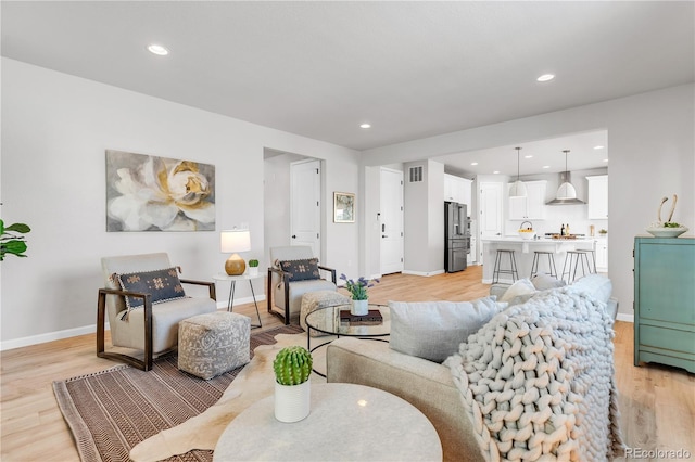 821 Boulder Peak Ave, Erie, CO 80516 - living room featuring light wood-type flooring, baseboards, and recessed lighting