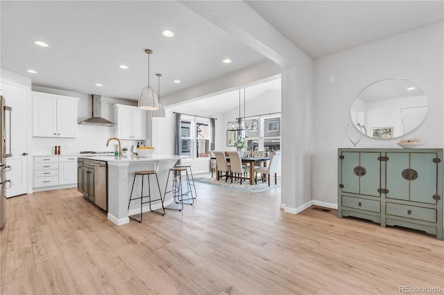 821 Boulder Peak Ave, Erie, CO 80516 - kitchen with wall chimney exhaust hood, light countertops, a kitchen island with sink, white cabinets, and recessed lighting