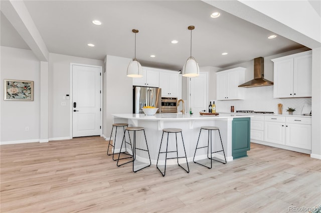 821 Boulder Peak Ave, Erie, CO 80516 - kitchen with wall chimney exhaust hood, stainless steel fridge, a kitchen bar, light wood-type flooring, and backsplash