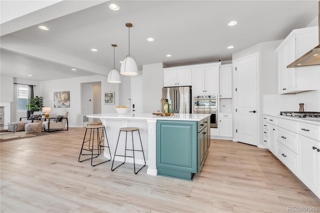 821 Boulder Peak Ave, Erie, CO 80516 - kitchen featuring appliances with stainless steel finishes, white cabinets, open floor plan, blue cabinets, and light countertops