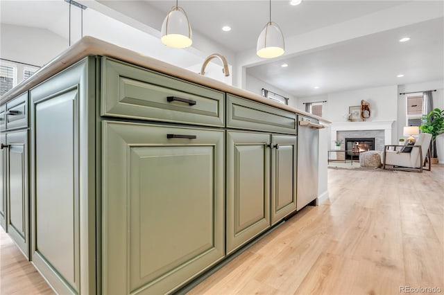 821 Boulder Peak Ave, Erie, CO 80516 - kitchen featuring green cabinets, light wood finished floors, open floor plan, recessed lighting, and decorative light fixtures