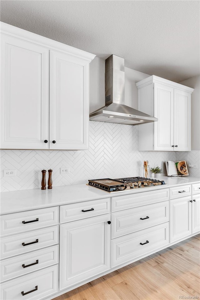 821 Boulder Peak Ave, Erie, CO 80516 - kitchen featuring wall chimney exhaust hood, stainless steel gas stovetop, light countertops, backsplash, and a textured ceiling