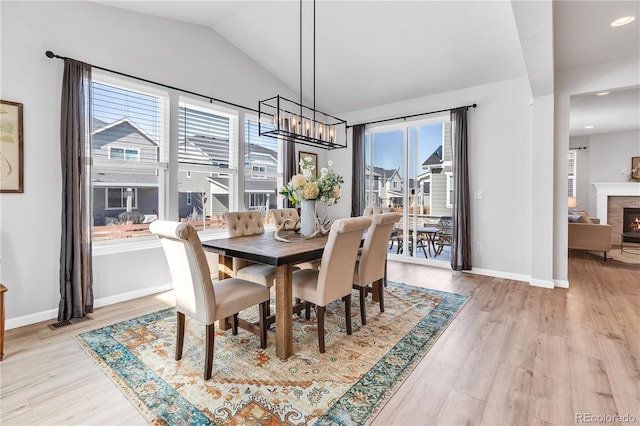821 Boulder Peak Ave, Erie, CO 80516 - dining space with a chandelier, light wood-style floors, vaulted ceiling, baseboards, and recessed lighting