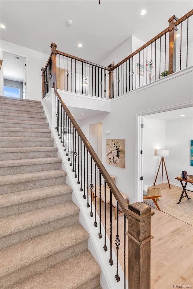 821 Boulder Peak Ave, Erie, CO 80516 - stairs with recessed lighting, wood finished floors, baseboards, and a high ceiling