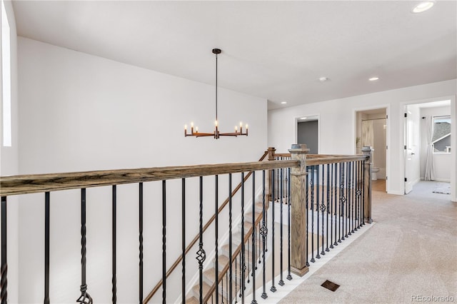 821 Boulder Peak Ave, Erie, CO 80516 - corridor featuring a chandelier, light colored carpet, an upstairs landing, recessed lighting, and baseboards
