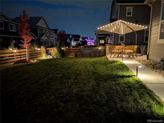 821 Boulder Peak Ave, Erie, CO 80516 - yard at night featuring a patio area and a residential view