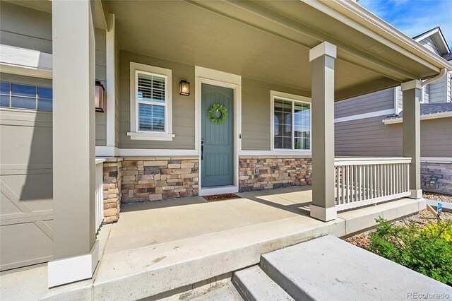 821 Boulder Peak Ave, Erie, CO 80516 - view of exterior entry with covered porch and stone siding