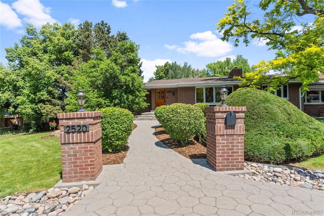 2520 Eldridge Cir, Golden, CO 80401 - view of front facade featuring a front lawn, a chimney, and brick siding