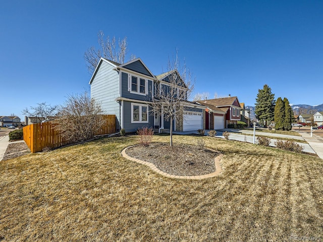 traditional home with concrete driveway, fence, a front lawn, and an attached garage