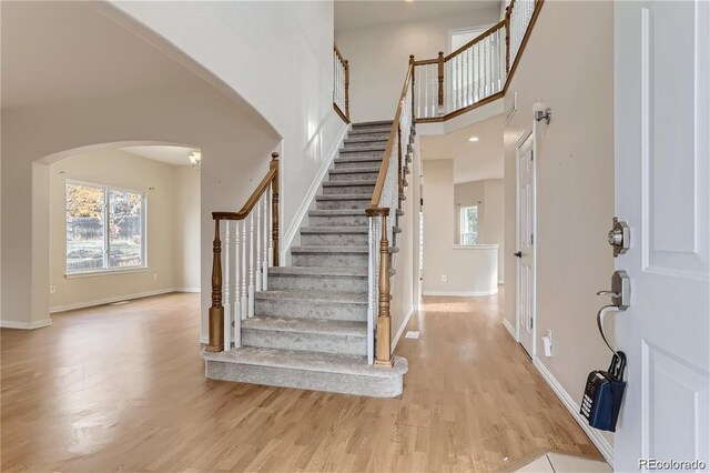 foyer with a high ceiling and light hardwood / wood-style floors