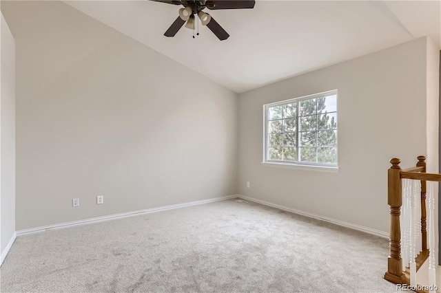 carpeted spare room with ceiling fan and vaulted ceiling