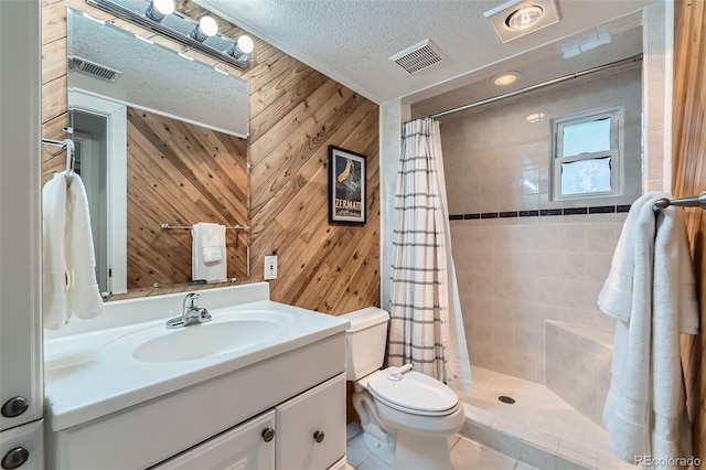3955 S Nucla St, Aurora, CO 80013 - bathroom featuring a textured ceiling, vanity, wooden walls, and a tile shower