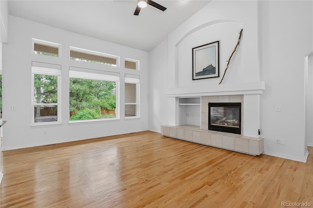 5926 S Elkhart Ct, Centennial, CO 80016 - unfurnished living room with vaulted ceiling, a ceiling fan, wood finished floors, and a tile fireplace