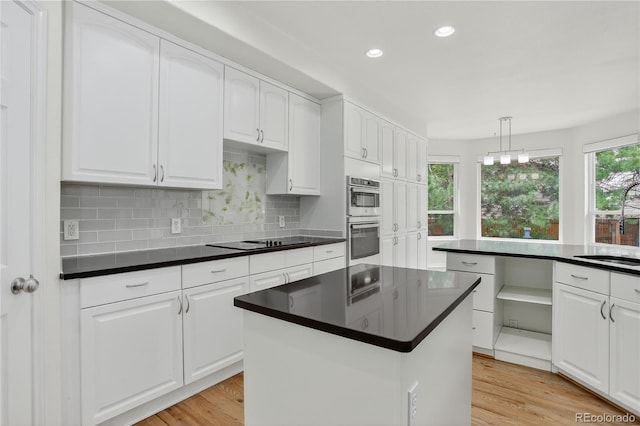 5926 S Elkhart Ct, Centennial, CO 80016 - kitchen featuring dark countertops, stainless steel double oven, black electric stovetop, recessed lighting, and a kitchen island