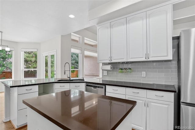 5926 S Elkhart Ct, Centennial, CO 80016 - kitchen featuring a peninsula, stainless steel appliances, dark countertops, healthy amount of natural light, and recessed lighting