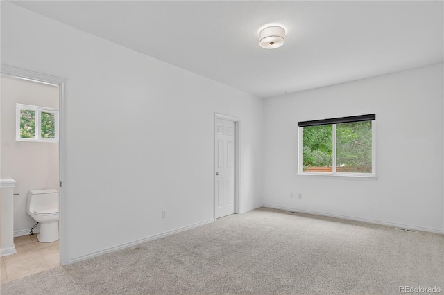5926 S Elkhart Ct, Centennial, CO 80016 - unfurnished bedroom featuring multiple windows, connected bathroom, and light carpet