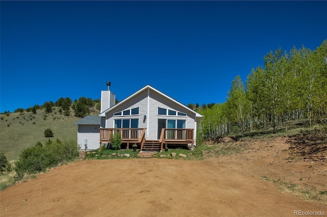 1536 County Road 1, Cripple Creek, CO 80813 - back of property featuring a chimney and a wooden deck