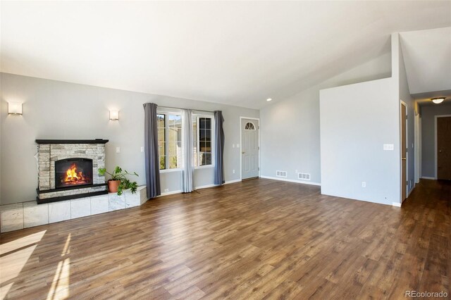 1536 County Road 1, Cripple Creek, CO 80813 - unfurnished living room featuring wood finished floors, a stone fireplace, lofted ceiling, and baseboards