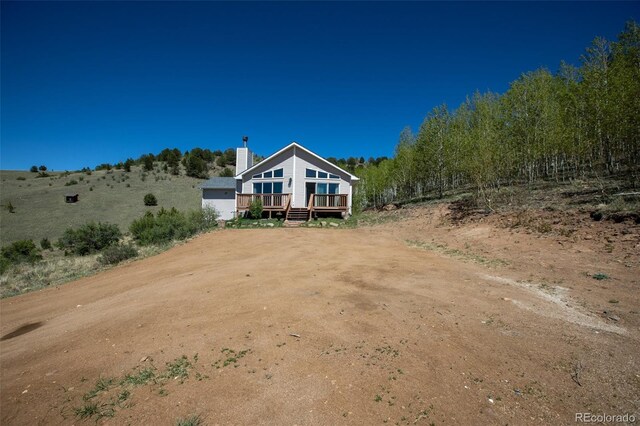1536 County Road 1, Cripple Creek, CO 80813 - rear view of property featuring a wooden deck and a chimney