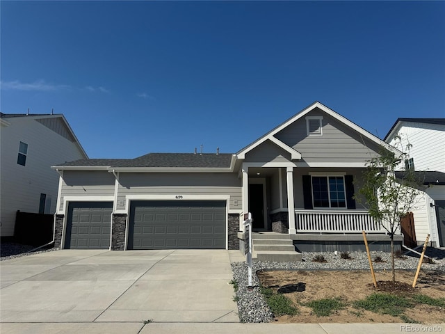 6170 Amerifax Dr, Windsor, CO 80528 - view of front facade featuring an attached garage, covered porch, concrete driveway, and stone siding