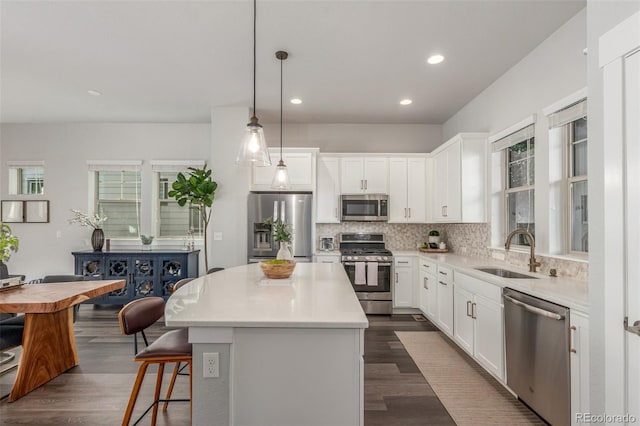 5735 Boston St, Denver, CO 80238 - kitchen featuring stainless steel appliances, a center island, tasteful backsplash, dark wood finished floors, and recessed lighting