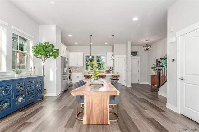 5735 Boston St, Denver, CO 80238 - kitchen with light countertops, white cabinets, dark wood finished floors, freestanding refrigerator, and a center island