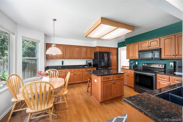1387 Mcintosh Ave, Broomfield, CO 80020 - kitchen with black appliances, light wood-style flooring, a kitchen island, and decorative light fixtures