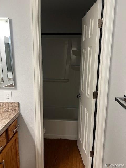 full bathroom featuring toilet, shower / washtub combination, wood finished floors, and vanity