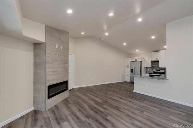 unfurnished living room featuring wood-type flooring, a fireplace, and vaulted ceiling