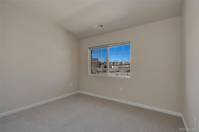 carpeted spare room featuring lofted ceiling