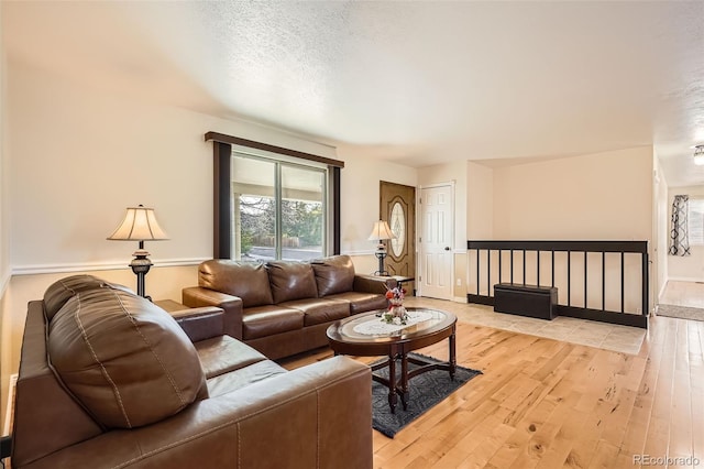 living room featuring light wood-style flooring and a textured ceiling
