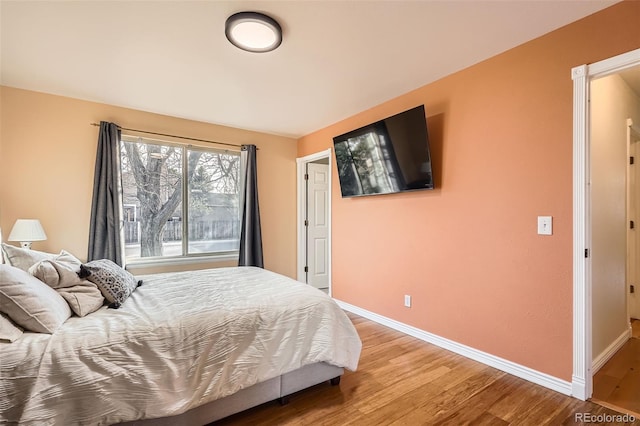 bedroom with light wood-type flooring and baseboards