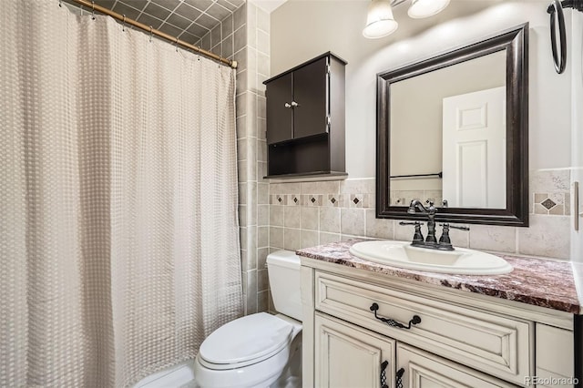 bathroom with tile walls, vanity, curtained shower, and toilet